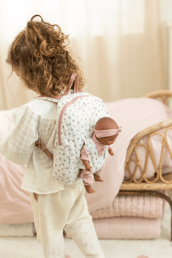 Little Dutch, Doll Carrier in soft pink with a child carrying a doll in a floral backpack.