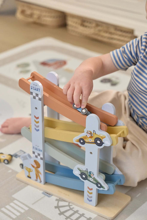 Child playing with Little Dutch, Ramp Racer - Cars, launching cars from the start to the finish line.