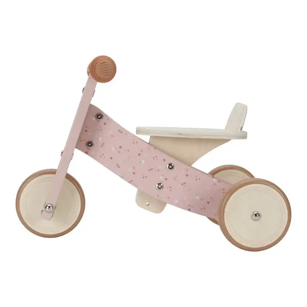 Little Dutch pink wooden tricycle for kids with adjustable seat and rubberized wheels for safety and comfort.