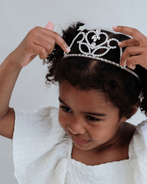 Little girl wearing a sparkling Mimi & Lula, Classic Princess Tiara, with a joyful expression.