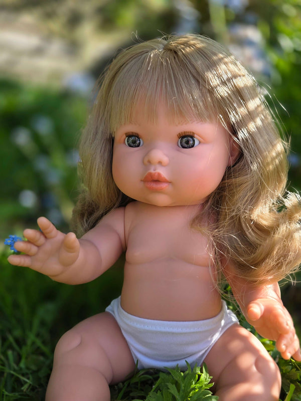 Mini Colettos doll named Kate with blonde hair and blue eyes, designed for imaginative play in nature.