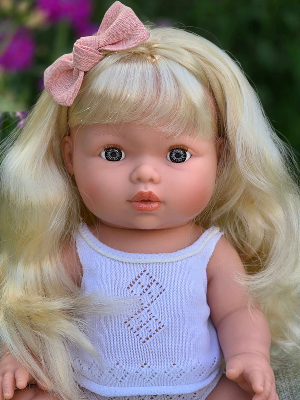 Mini Colettos, Sage (Light Blonde Hair with Blue Eyes) doll with long blonde hair and pink bow.