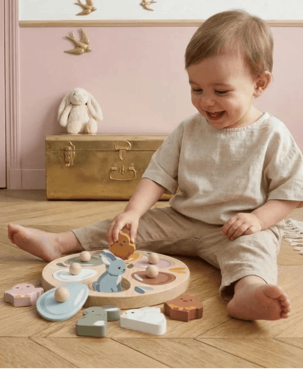 Child playing with Speedy Monkey, Garden Surprise Puzzle, exploring colorful wooden animal shapes.