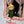 Olli Ella Dress Me Dinky Charlie Chestnut doll peeking out from a colorful playhouse window, wearing a yellow beanie and green coat.