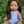 Mini Colettos, Isabel (Hispanic Girl, Brown Straight Hair and Blue Eyes) sitting in grass with blue outfit.
