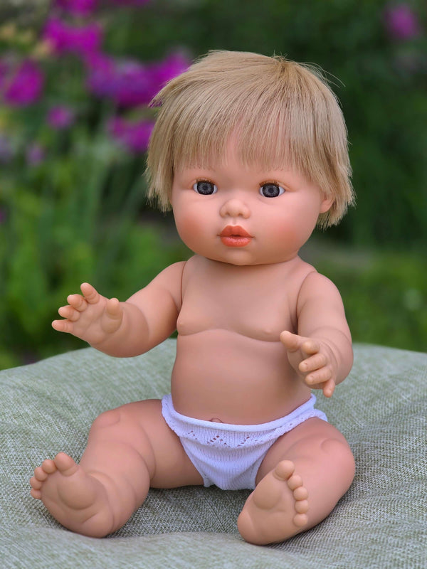 Mini Colettos, Oliver, Blonde Boy with Blue Eyes doll sitting, cheerful expression, blonde hair, blue eyes.