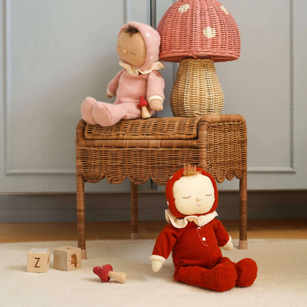 Two Dozy Dinkum dolls on a wicker stool beside a mushroom lamp, creating a cozy, magical playroom scene.